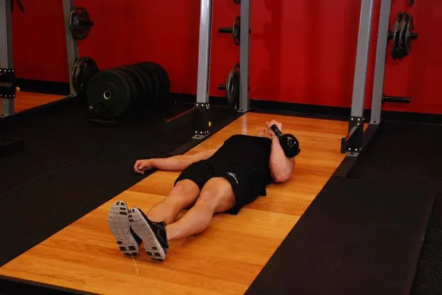 One-Arm Kettlebell Floor Press, starting position
